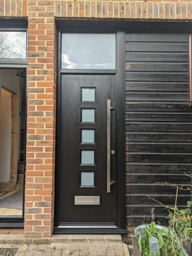 A ginormous Black Manhattan Rockdoor with a stunning Offset Stainless Steel Square Bar Handle and a Coastal letter box fitted in Teddington